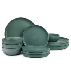 a set of green dinnerware with plates and bowls on the bottom, in front of a white background