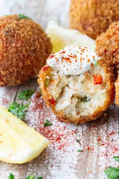 some food is sitting on a table with lemons and parmesan cheese balls