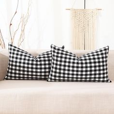 two black and white pillows sitting on top of a couch