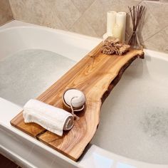 a bathtub with soap and candles in the tub, next to it is a wooden cutting board