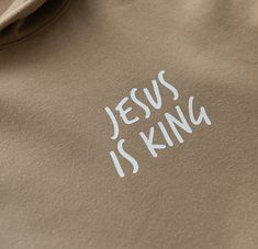 the word jesus is king printed on a brown sweatshirt