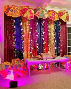 a room decorated in bright colors with umbrellas hanging from the ceiling