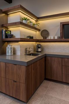 a modern kitchen with wooden cabinets and counter tops, along with a microwave oven on the wall