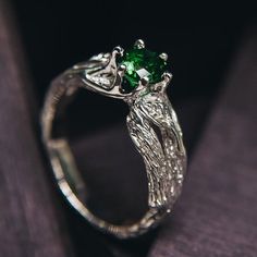 "Step into the enchanting world of autumn with this elegant silver leaf ring adorned with a shiny emerald. Ideal for nature lovers, it captures the essence of the season in a stunning piece of jewelry. This ladies' emerald green ring is a tribute to the beauty of plants and nature, making it a unique and cherished addition to your collection. DETAILS: Stone - 6mm Lab Grown Emerald Metal - recycled solid Sterling Silver Dimensions - width 6mm (0.23 in.), band width - 3mm (0.118 in.) Finish - oxidized (shiny at your request - shown in the last 3 photo) HOW TO ORDER ▪   Simply choose your ring size and a gemstone in dropdown menus. ▪   Add an engraving you'd like to have inside in the 'Personalization Box' (optionally). ▪   Feel free to contact me if you want to change anything about the ring Nature-inspired Silver Emerald Jewelry, Emerald Ring Leaves, Nature-inspired Green Emerald Gemstone Ring, Handmade Nature-inspired Green Emerald Ring, Silver Emerald Ring For Gift, Nature-inspired, Emerald Green Ring, Silver Leaf Ring, Ring With Emerald, Green Emerald Ring