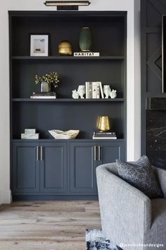 a living room with black bookcases and gold accents on the shelves in front of it