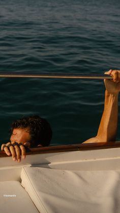 a man is resting his head on the edge of a boat