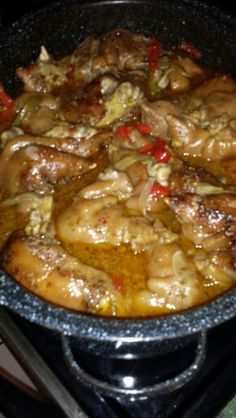 a pan filled with meat and vegetables on top of a stove