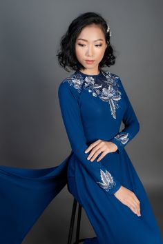 Beautiful custom-made ao dai in dark blue silk. Spectacular, machine embroidered floral design. Price includes dress and pants. After your purchase is complete, we will email you a link to a simple online form to enter your measurements - we will then create the most flattering custom fit for your individual body type. Shipping details Please allow up 4 weeks for custom making and shipping, once measurements are received. Please note; we make every effort to ensure our photos accurately represen Traditional Drape Evening Dresses For Spring, Spring Evening Dress With Traditional Drape, Festive Blue Dress With Embroidered Sleeves, Blue Wedding Dresses With Embroidered Sleeves, Elegant Dress With Embroidered Sleeves And Traditional Drape, Fitted Blue Gown With Floral Embroidery, Blue Dress With Resham Embroidery For Evening, Blue Evening Dress With Resham Embroidery, Traditional Blue Dress With Embroidered Sleeves