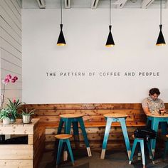 two people sitting at a table in front of a sign that says the pattern of coffee and people