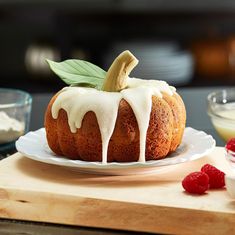 a bundt cake with icing and raspberries on a plate