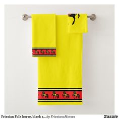 two yellow towels hanging on a towel rack with horse images printed on the front and back