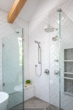 a bathroom with a walk in shower next to a bathtub and sink under a wooden beam