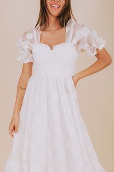 Indulge in a playful afternoon with our EXCLUSIVE Afternoon With You Dress. This white dress features delicate floral accents, puff sleeves, and a corset bodice for a flirty touch. Elastic along the shoulders and cuffs, corset tie back, and invisible zipper closure ensure a comfortable and perfect fit. Complete with ruffle details and a tier hem for a whimsical look. Say yes to this must-have dress! Details *Measurements are taken with item hanging and fabric unstretched.* White dress with white Short Sleeve Coquette Dresses For Spring, Summer Puff Sleeve Coquette Dresses, Summer Coquette Dress With Puff Sleeves, Coquette Short Sleeve Dresses For Spring, Coquette Short Sleeve Spring Dresses, Puff Sleeve Fitted Bodice Dress For Garden Party, Puff Sleeve Dress With Fitted Bodice For Garden Party, Spring Empire Waist Fitted Corset Dress, Feminine Spring Corset Dress For Brunch