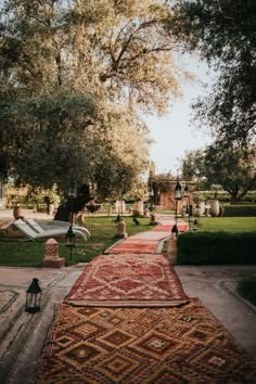 an old rug is laying on the ground in front of some trees and lawn chairs