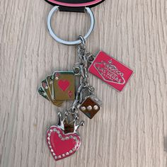 a keychain with several different items on it and a cell phone in the background