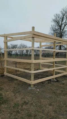 a wooden structure sitting on top of a dry grass field