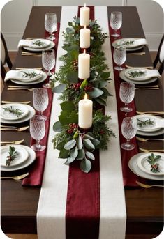 the table is set for christmas with candles and greenery on it, along with other place settings