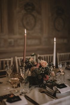 the table is set with flowers and candles