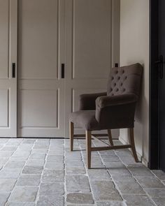 a chair sitting in front of a closet with two doors and a door way to another room