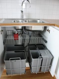 the kitchen sink is open and has several containers in it, which are stacked on top of each other