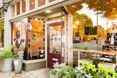 an outside view of a coffee shop with potted plants