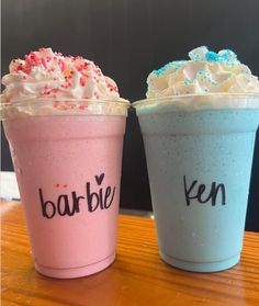 two drinks with whipped cream and sprinkles on them sitting next to each other