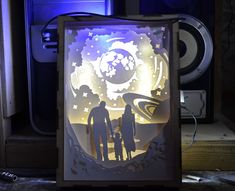 a paper cut out of two people standing next to each other in front of speakers