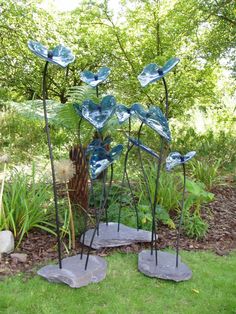 three metal sculptures sitting in the grass