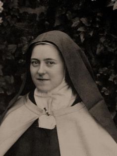 an old black and white photo of a woman wearing a nun's outfit with a hood