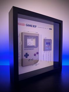 an old game boy is displayed in a glass case