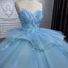 Step into a fairytale with this romantic princess quinceanera dress. This enchanting dress is made from delicate lace fabric in a dreamy sky blue color. The strapless neckline and sleeveless design create an elegant look, while the cathedral train adds a touch of grandeur to this dress. With the appliqued details and ruffled embellishments, this gown is perfect for making your quinceanera celebration unforgettable. Details: Silhouette: Ball Gown Style Fabric: Lace Fabric Color: Sky Blue Color Le Baby Blue Quinceanera Dresses, Champagne Quinceanera Dresses, Sequin Ball Gown, White Quinceanera Dresses, Romantic Princess, Purple Quinceanera Dresses, Quinceanera Dresses Gold, Black Quinceanera Dresses, Satin Ball Gown