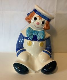 a ceramic figurine with a hat and bow tie on it's head