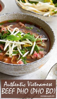 a bowl of beef pho soup with noodles and herbs