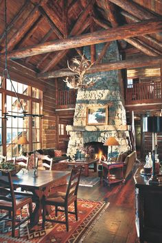 a living room filled with furniture and a fire place next to a stone fireplace covered in wood