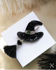 black beaded witch hat brooch with tassels and beads on white card