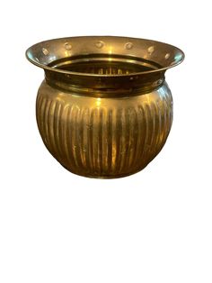 a large brass vase sitting on top of a white surface