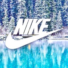 the nike logo is displayed in front of a lake with snow covered trees behind it