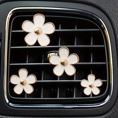 four flower shaped knobs in the center of a car's air conditioner