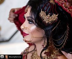 a woman with dark hair and gold jewelry on her head is getting ready to go into the wedding ceremony