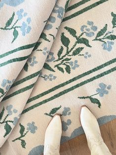 a person standing on top of a rug with their feet propped up against the floor