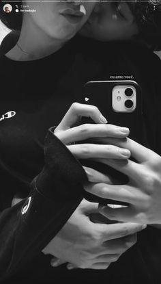 black and white photograph of two people holding their cell phones in front of each other