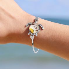 Exquisite and refined, the nautically-inspired Pressed Daisy Sea Turtle Bracelet adds a touch of elegance to any outfit. This unique bracelet is the perfect reminder of warmer weather and happy beach memories for your favorite beach lover.  Details:  Eco-friendly Alloy with Silver Finish Real Daisy in Resin Oval Size: 65mm (length) x 55mm (width) Sunshine on your neck, the ocean in your ears. Discover GoBeachy jewelry - where summer never fades. Dive into sun-kissed sparkle, where quality meets Ocean-inspired Jewelry With Lobster Clasp For Vacation, Ocean-inspired Jewelry For Vacation With Lobster Clasp, Bohemian Flower Bracelets For Vacation, Silver Flower Jewelry For Friendship, Adjustable Ocean-inspired Charm Bracelet With Lobster Clasp, Adjustable Silver Bracelet With Ocean-inspired Style, Adjustable Silver Bracelets With Ocean-inspired Style, Adjustable Silver Ocean-inspired Bracelets, Silver Adjustable Ocean-inspired Bracelets