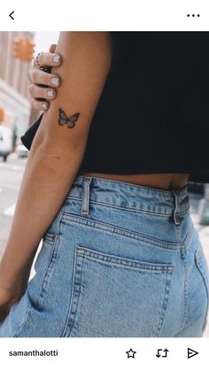 a woman with a butterfly tattoo on her left arm and the other hand behind her back