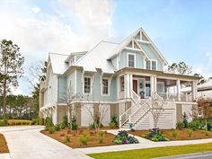 a blue house with white trim on the front and stairs leading up to it's second story