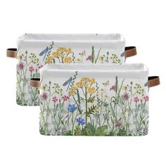 two white trays with colorful flowers and dragonflies on the front, one has brown leather handles