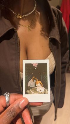 a woman holding up a small card with an image on it