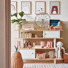 a room filled with furniture and pictures on the wall next to a potted plant