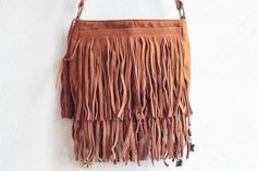 Made with combination of genuine suede leather (fringe, strap,body), faux suede (body) -Lined interior with magnetic snap and a back pocket that closes with zipper -Adjustable, leather shoulder strap - can be worn across the body or on the shoulder -The purse is double stitched in the stressed areas - Adornments include mixed fabrics, beads, feathers, jewelry MEASUREMENTS - Length 17 cm / 7 in - Width 3 cm / 1.5 in - Depth 21 cm / 8 in Bohemian Shoulder Bag With Adjustable Strap For Fall, Bohemian Leather Shoulder Bag For Summer, Bohemian Shoulder Bag For Fall, Bohemian Shoulder Bag With Tassels For Fall, Bohemian Fall Bags With Tassels, Bohemian Brown Shoulder Bag For Fall, Bohemian Brown Shoulder Bag With Fringe, Festival Fringe Shoulder Bag, Festival Fringe Hobo Shoulder Bag