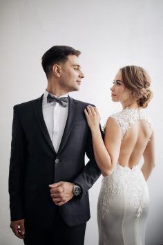 a man in a tuxedo standing next to a woman wearing a wedding dress