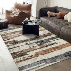 a living room filled with furniture and a large rug on top of a hard wood floor